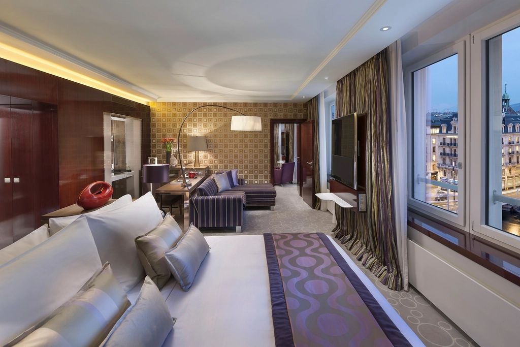 A guest room with a large bed and soft lighting